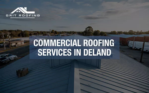 An aerial view of a large commercial metal roof in DeLand, featuring the GRIT Roofing logo and a blue banner with text that reads "COMMERCIAL ROOFING SERVICES IN DELAND."