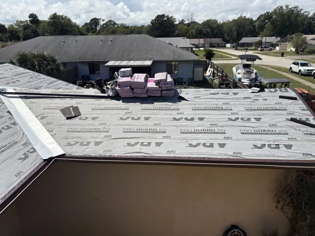 GRIT Roofing installing synthetic underlayment and staging shingles for a residential roof replacement in Port Orange, Florida.
